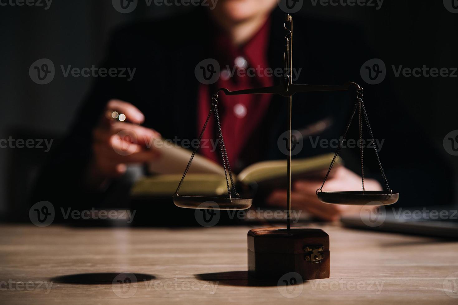 concepto de justicia y derecho. juez masculino en una sala de audiencias con el mazo, trabajando con computadora y teclado de acoplamiento, anteojos, en la mesa a la luz de la mañana foto