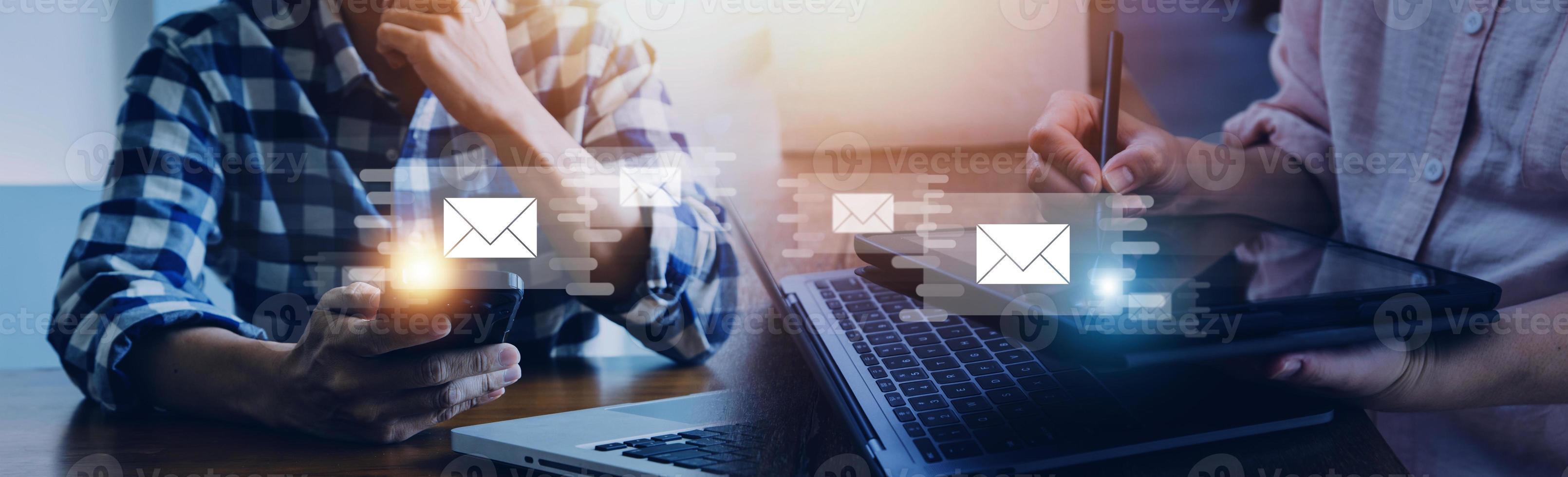 Businessman hands using Laptop typing on keyboard and surfing the internet on office table with email icon, email marketing concept, send e-mail or newsletter, online working internet network. photo