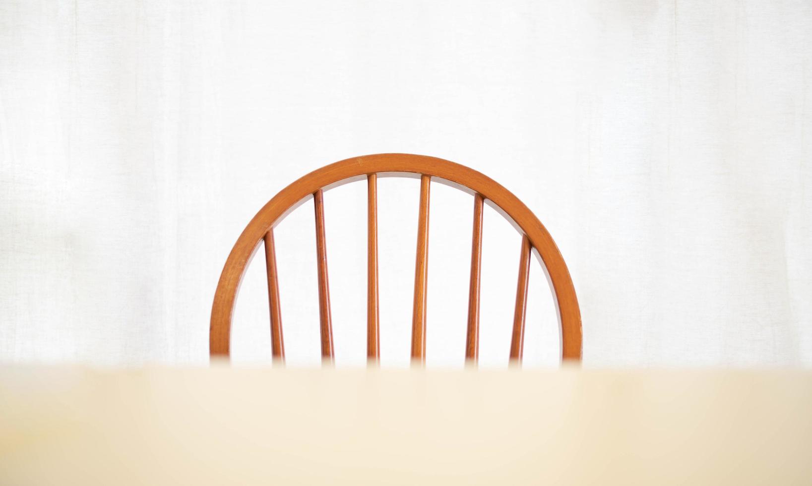 An empty wood dining table and chair with lighting lamp glowing, lonely abstract feeling. Home interior furniture object photo