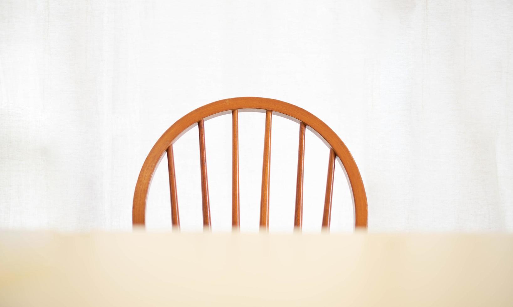 una mesa de comedor de madera vacía y una silla con una lámpara de iluminación que brilla intensamente, una sensación abstracta y solitaria. casa interior muebles objeto foto