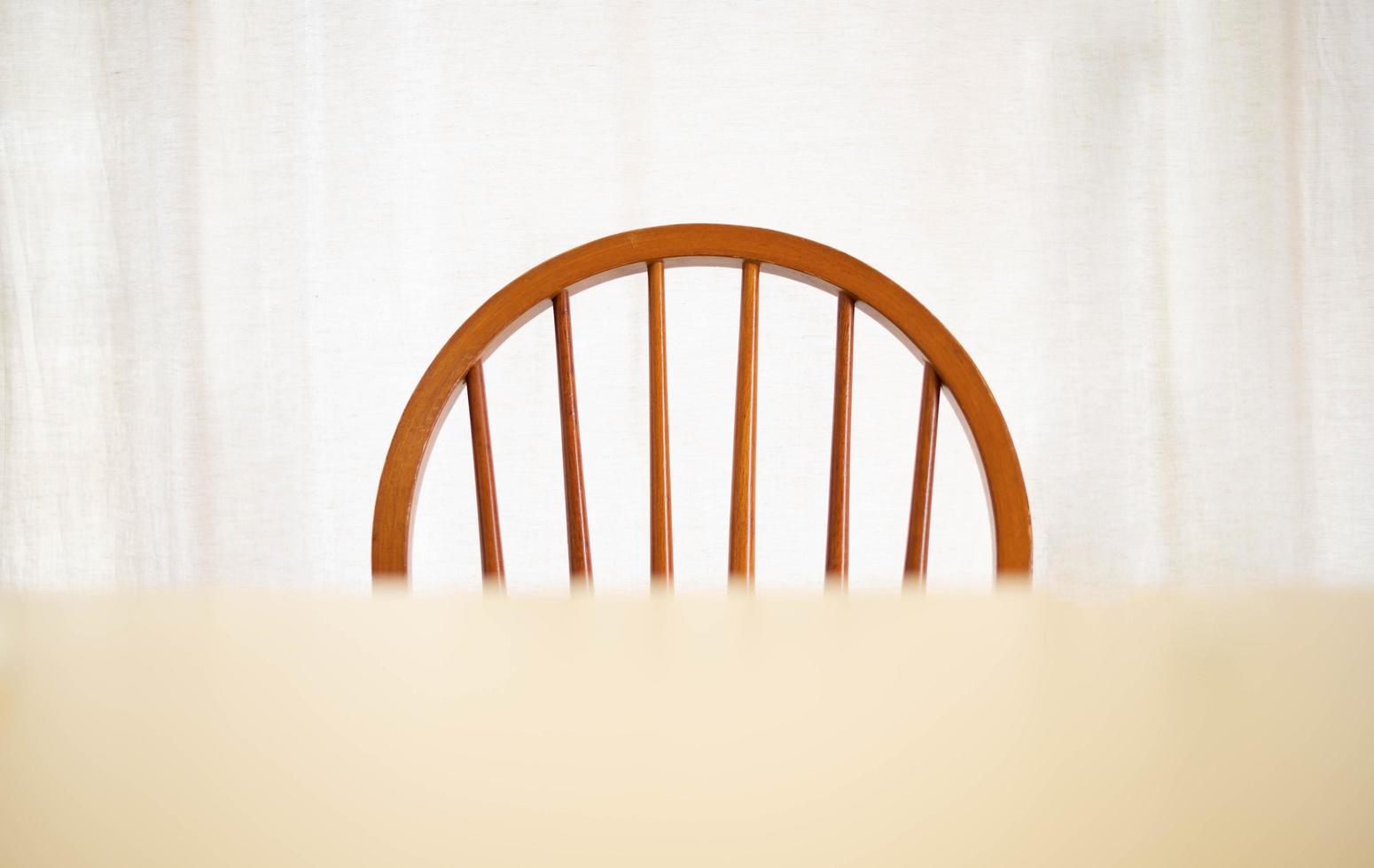 An empty wood dining table and chair with lighting lamp glowing, lonely abstract feeling. Home interior furniture object photo