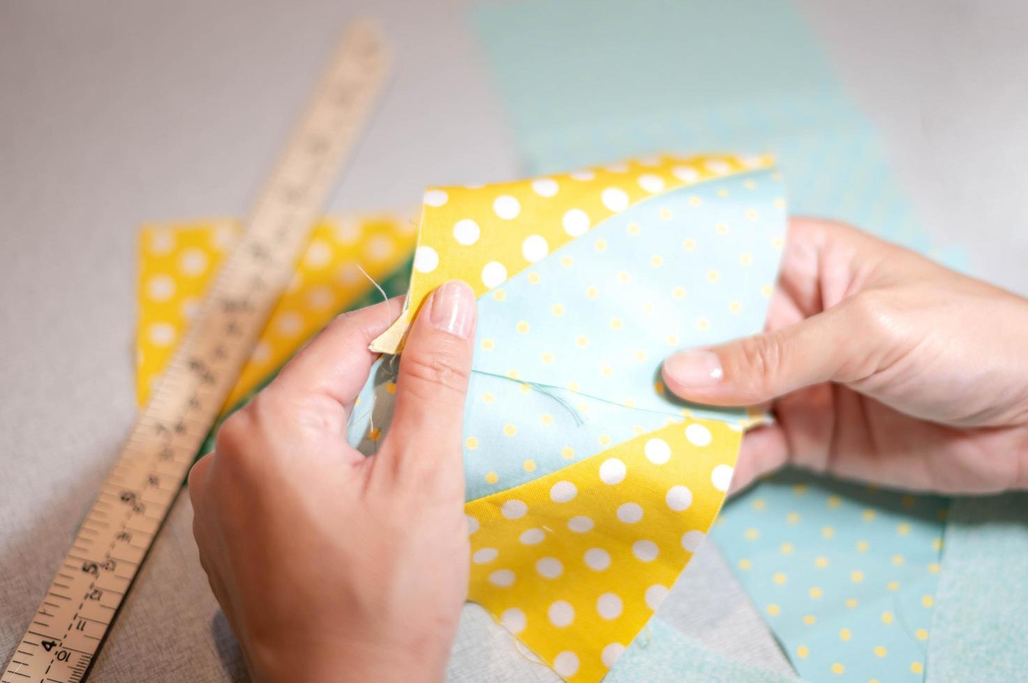 Female hands of designer at work with fabric close-up. Tailor measuring necessary amount of material for sewing cloth. photo