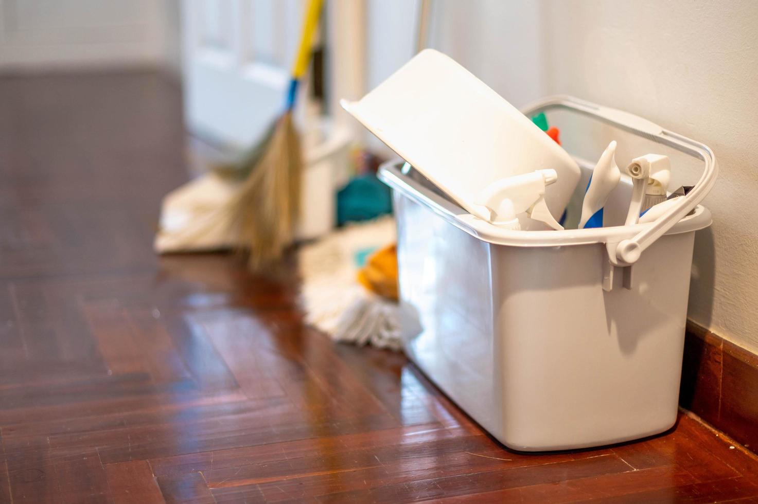 The Bucket with sponges, chemicals bottles and mopping stick. Rubber gloves and towel. Household equipment, cleaning service concept. photo