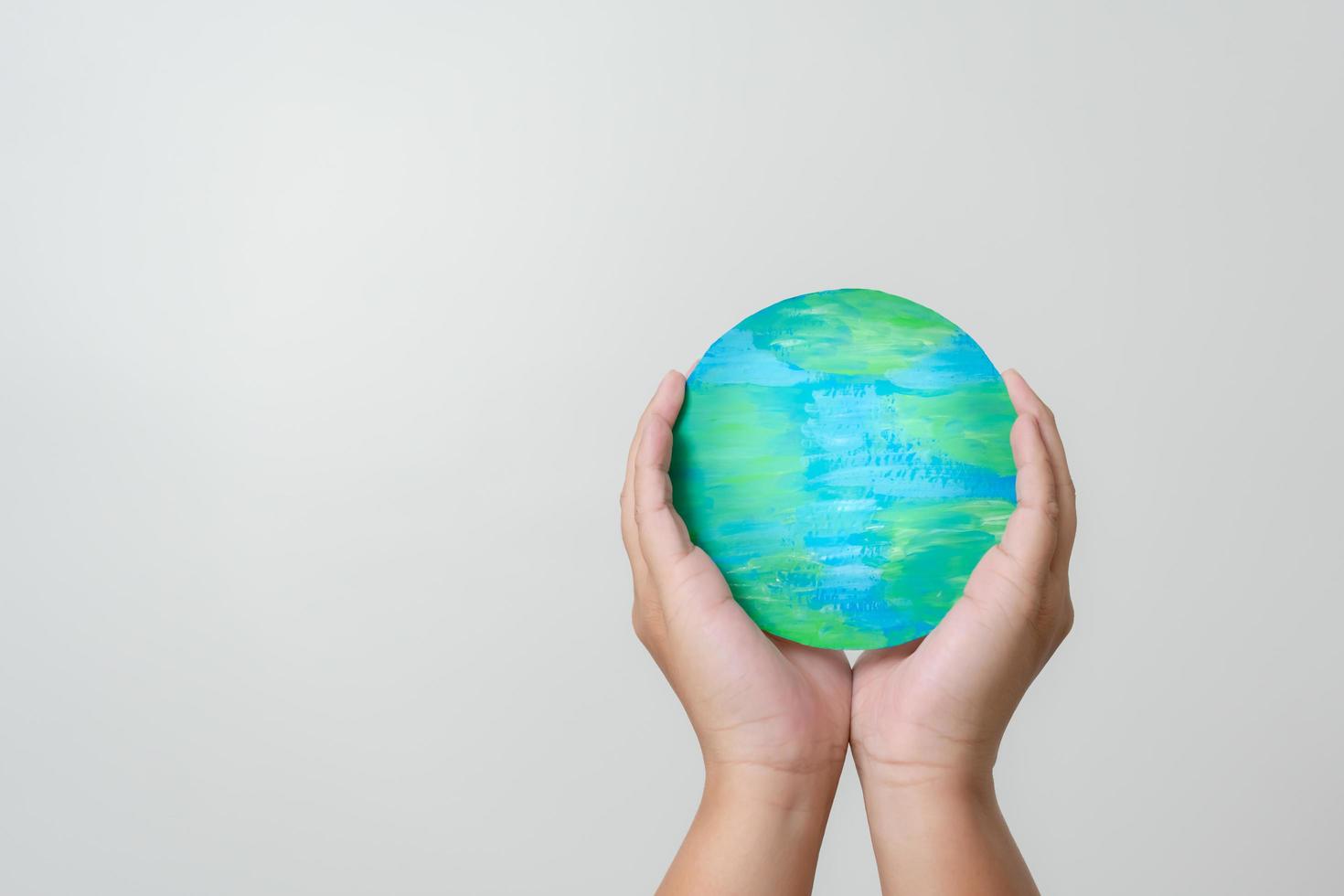 Woman hands holding paper colored earth element to empowered saving the world concept. Love and care to the earth. photo