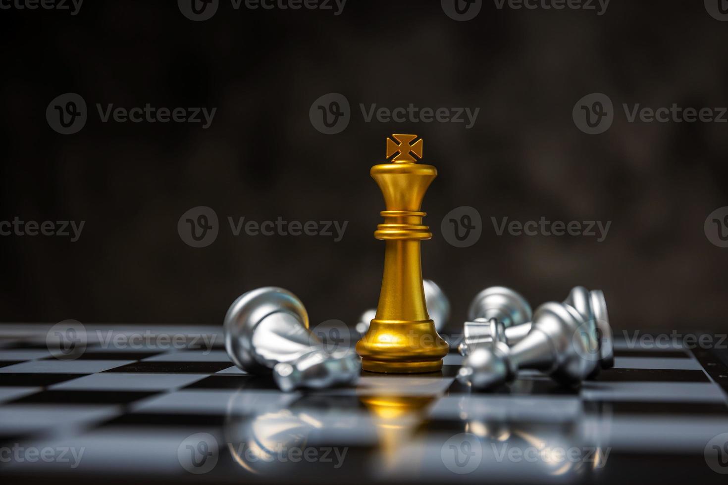 jefe de equipo. rey de oro rodeado de piezas de ajedrez de plata en la competencia de juegos de tablero de ajedrez con espacio de copia en fondo oscuro, batalla de ajedrez, éxito, líder de equipo, trabajo en equipo, concepto de estrategia de negocios foto