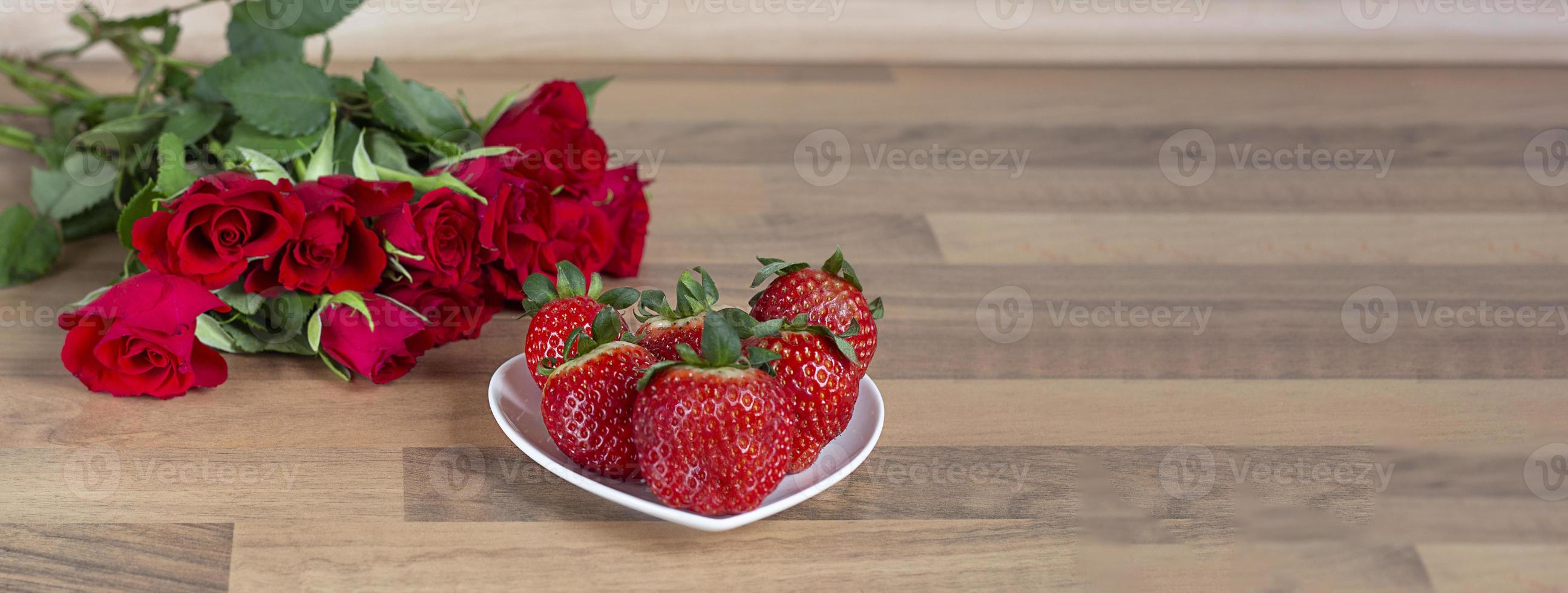 Valentine. Valentine background. Valentine's day concept red roses and strawberries in a plate photo
