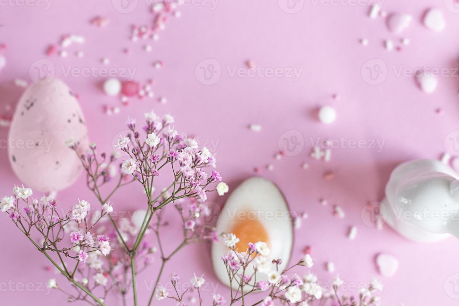 Easter background with colored Easter eggs and blooming flowers on a pink background. easter copy space photo