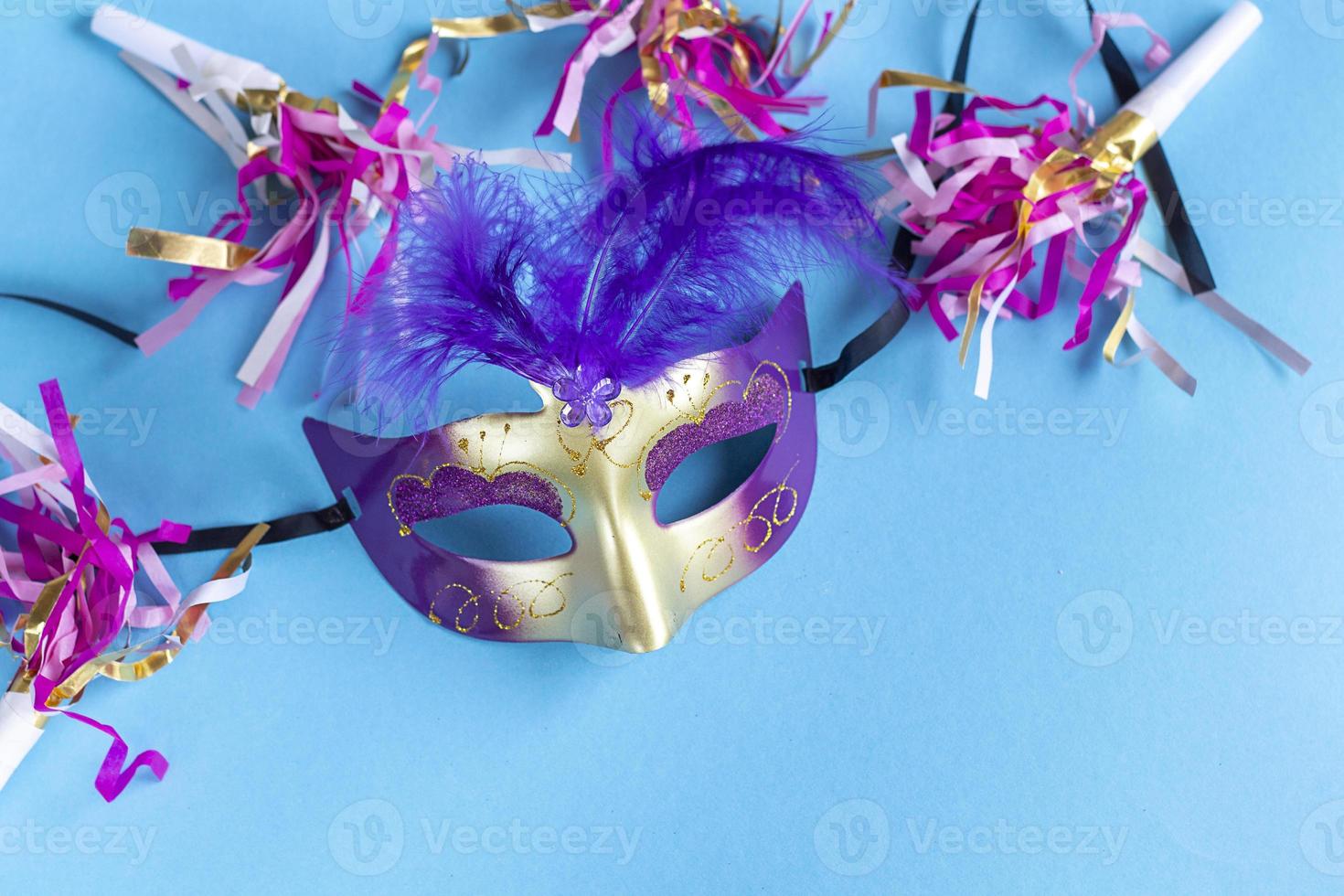 Festive face mask for carnival celebration on blue background. Mardi gras carnival background with carnival masks. Flat lay carnival concept. photo