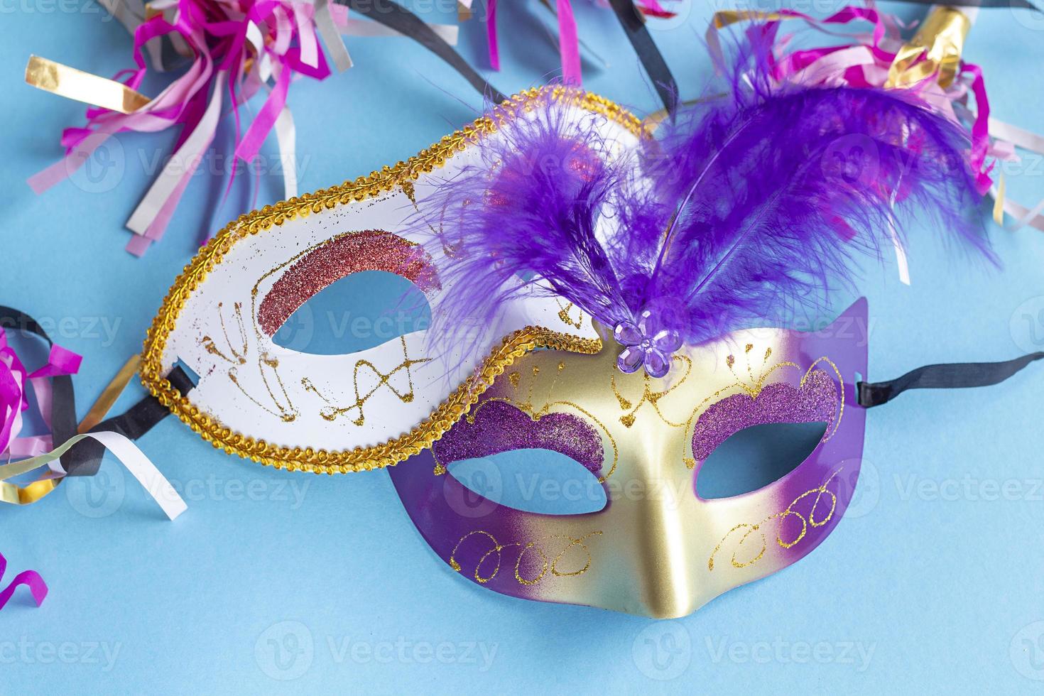 Festive face mask for carnival celebration on blue background. Mardi gras carnival background with carnival masks. photo