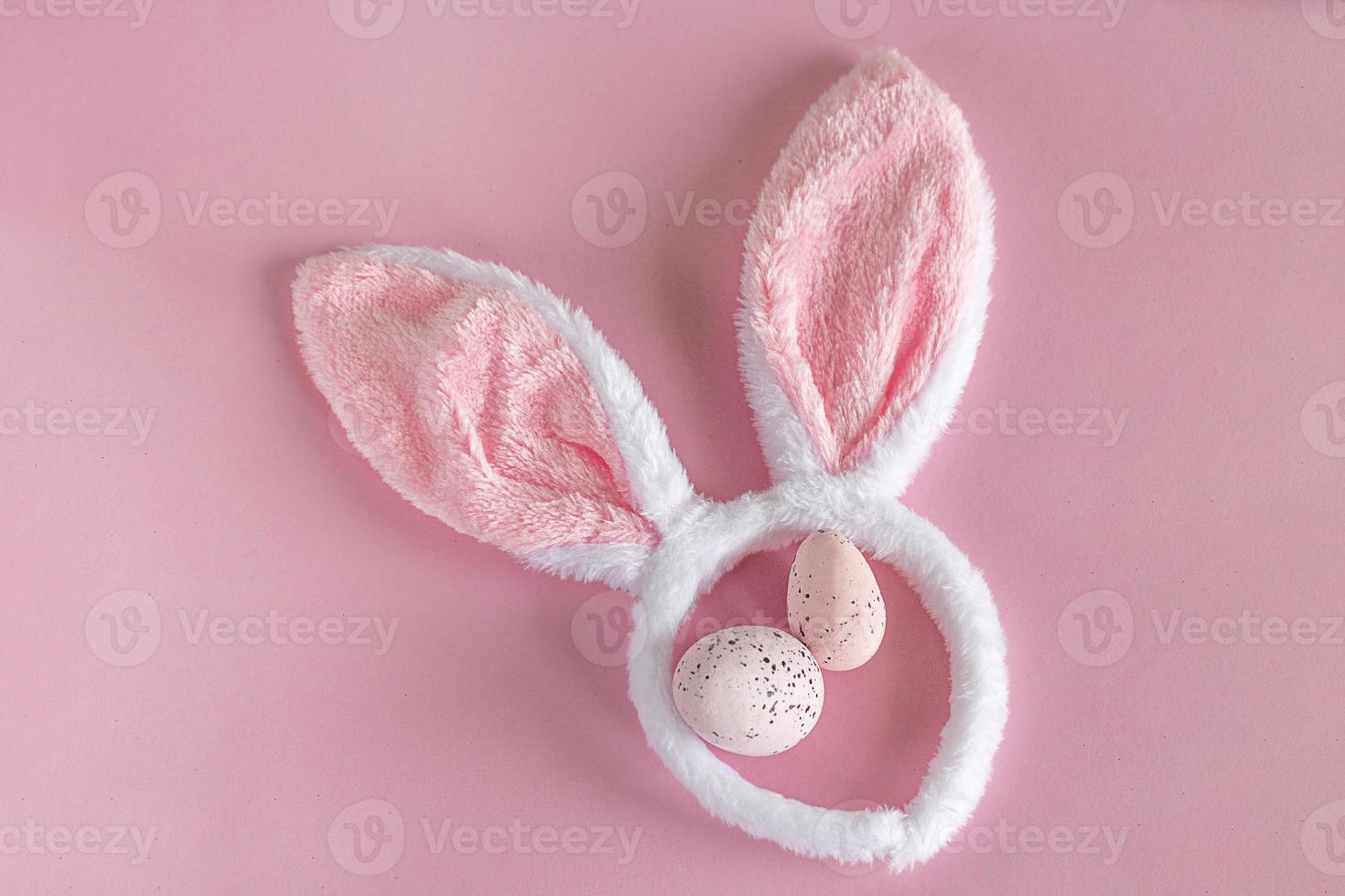 Easter background. Pink Easter bunny ears on a pink background. Easter eggs. Easter. copy space photo