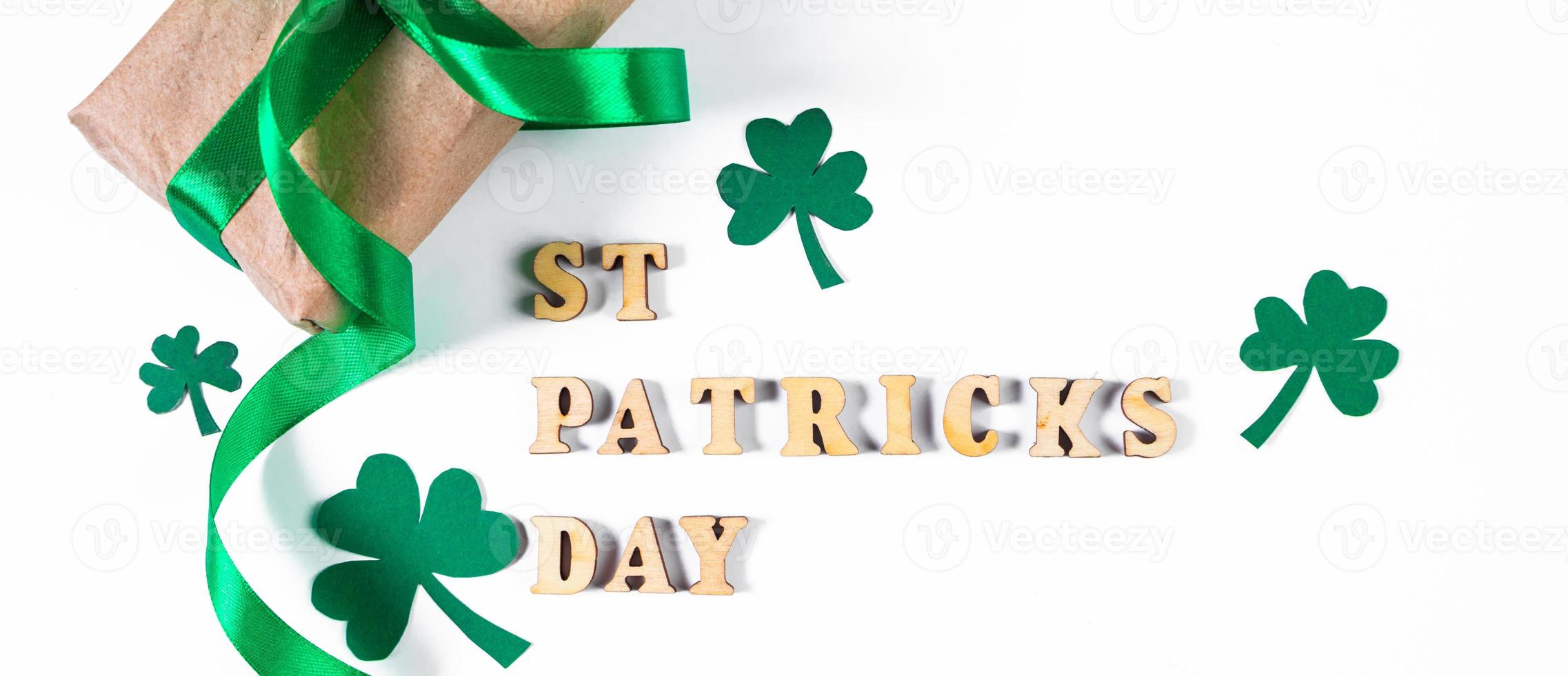 Shamrock and gift with green ribbon on a white background. Good luck symbols for St. Patrick's Day. Irish holiday. photo