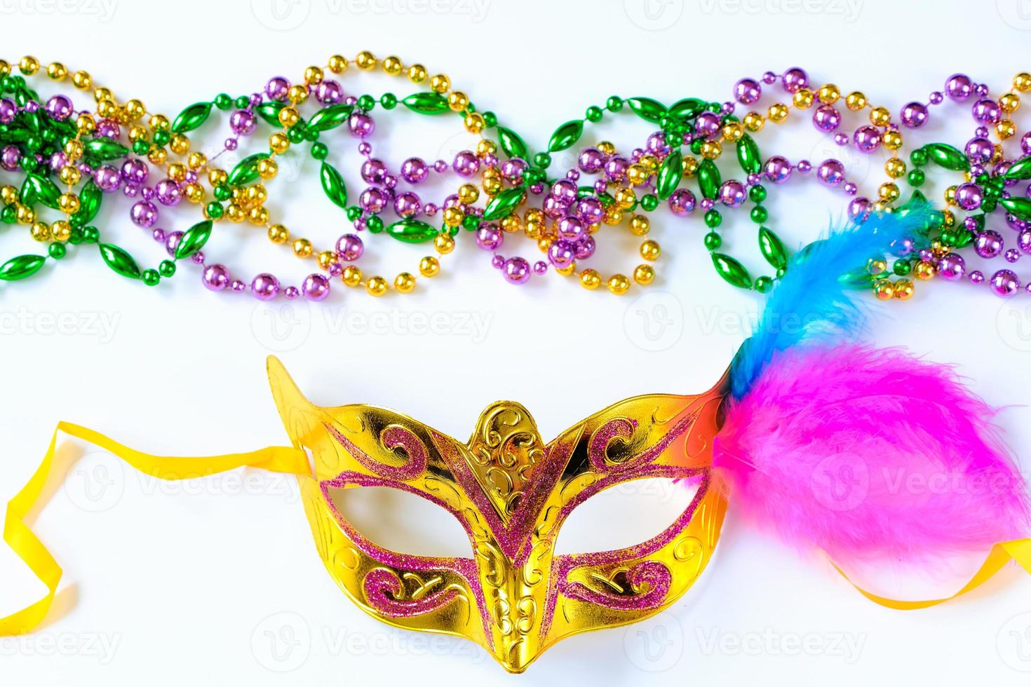 Carnival mask with feathers and colorful beads on white background. Mardi Gras or Fat Tuesday symbol. photo