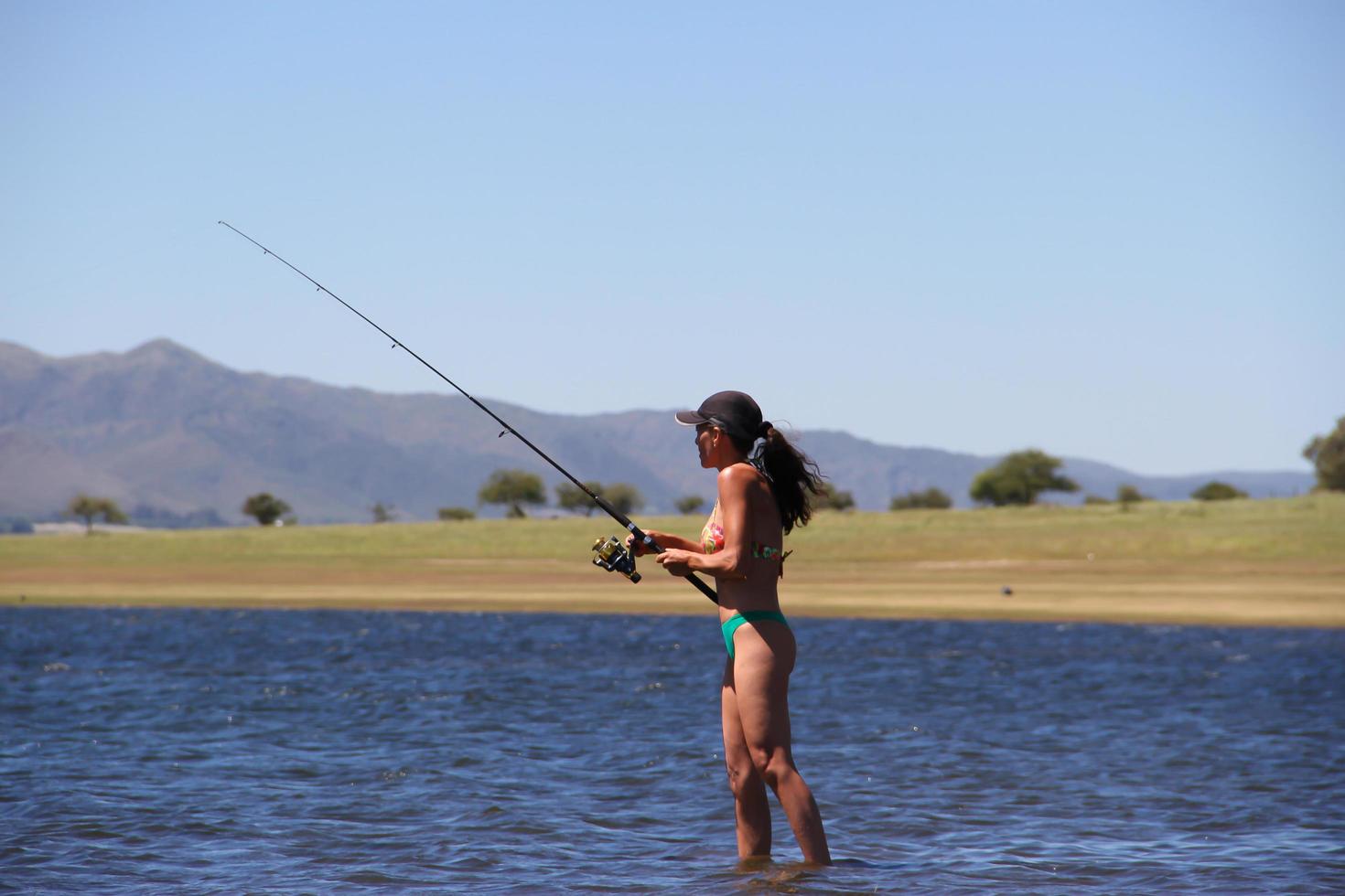 hermosa joven pescando en el lago de la montaña foto