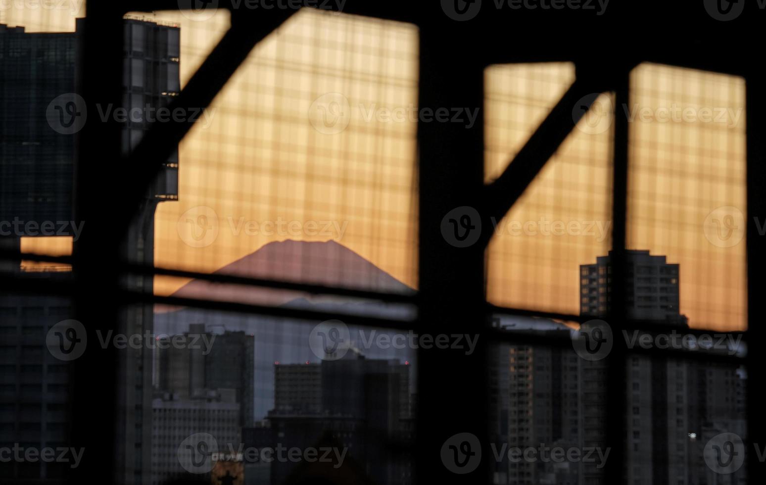 monte fuji durante la puesta de sol visto entre edificios en tokio, japón foto