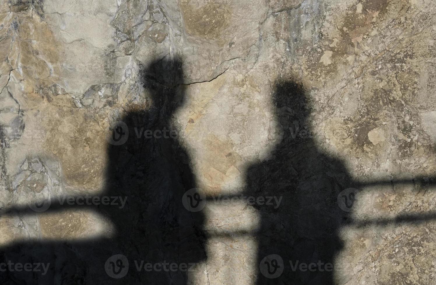 Shadow of two men on a rocky wall photo