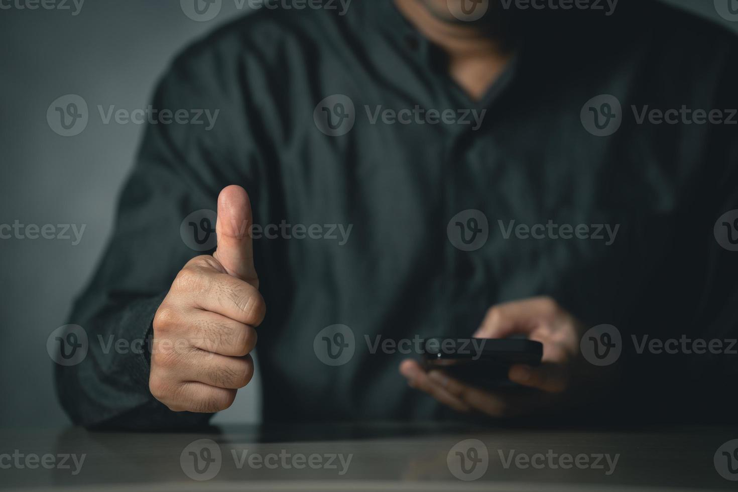 Freelance man thumbs up use mobile phone searching browsing internet data information. Search engine optimization SEO networking concept. businessman working with smartphone on desk. photo