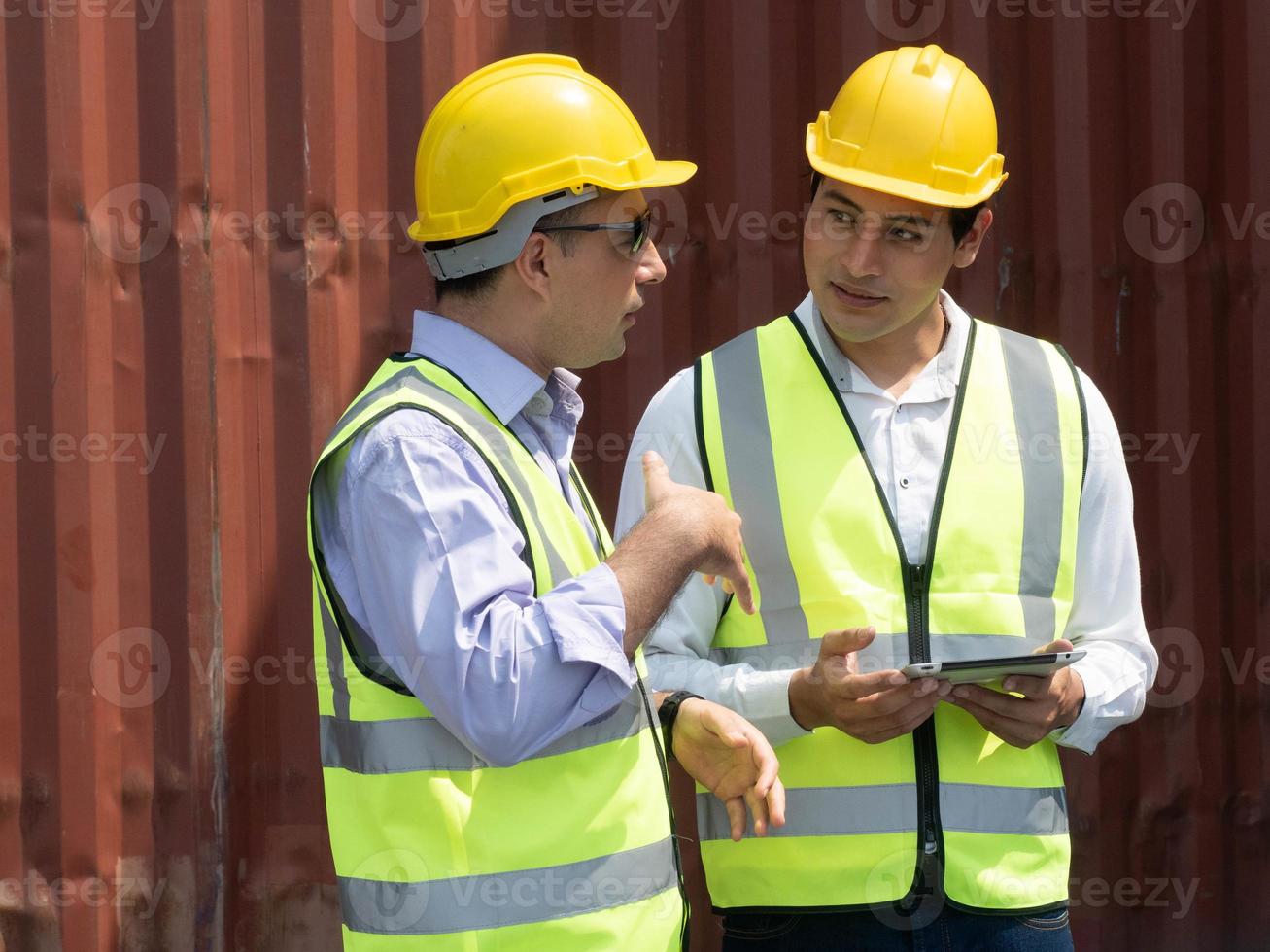 dos personas ingeniero masculino mano de obra personal empleado usar  uniforme amarillo casco casco seguridad hablar hablar discusión cuaderno  tableta informe información importación exportación envío logística carga  persona trabajo en equipo 18932630