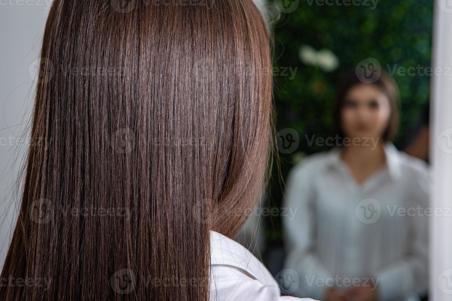 A straight healthy brunette hair that has undergone the hair straightening procedure. straight, shiny and healthy brunette hair photo
