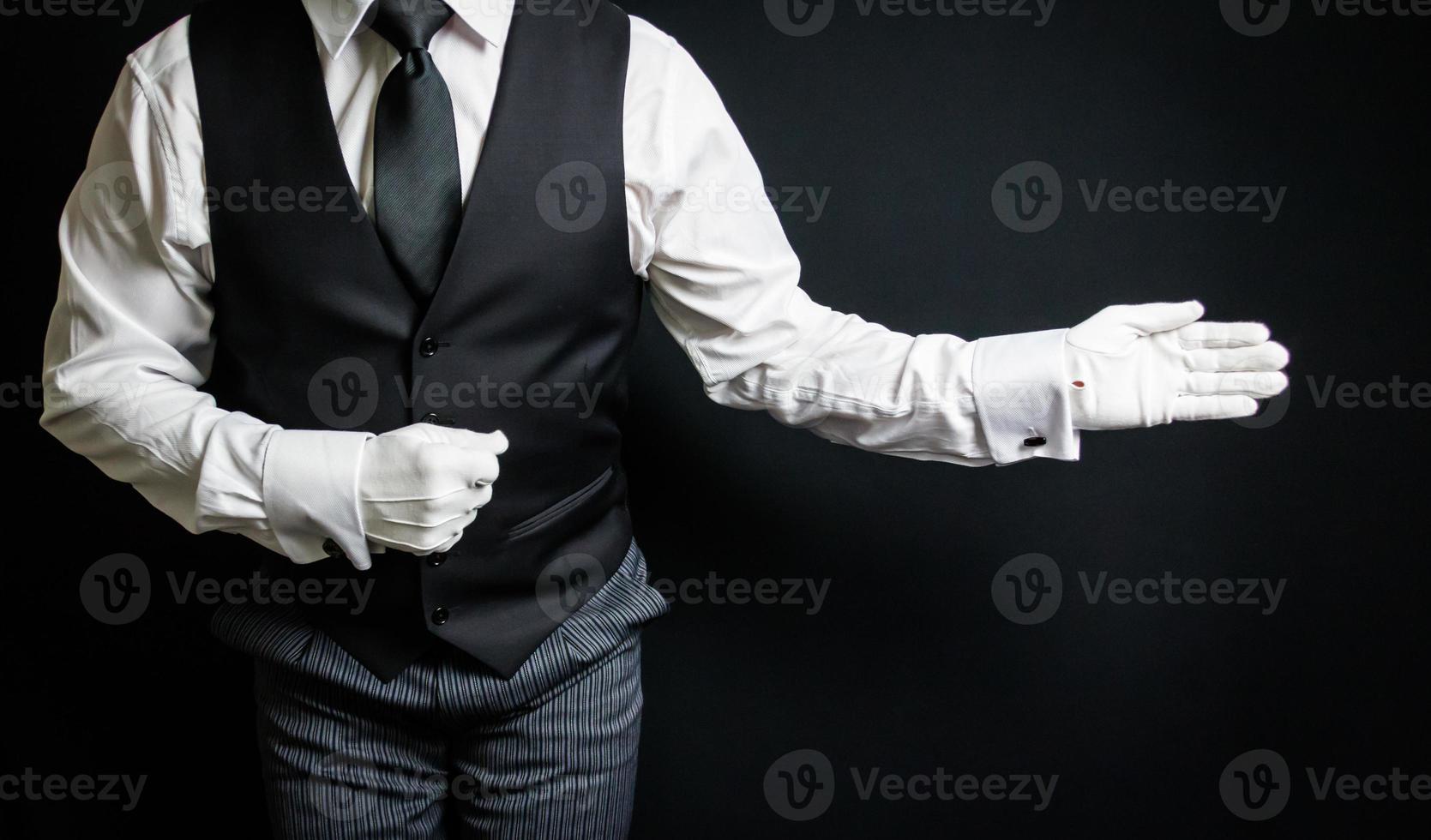 retrato de mayordomo con guantes blancos de pie con gesto de bienvenida. concepto de industria de servicios y hospitalidad profesional. foto