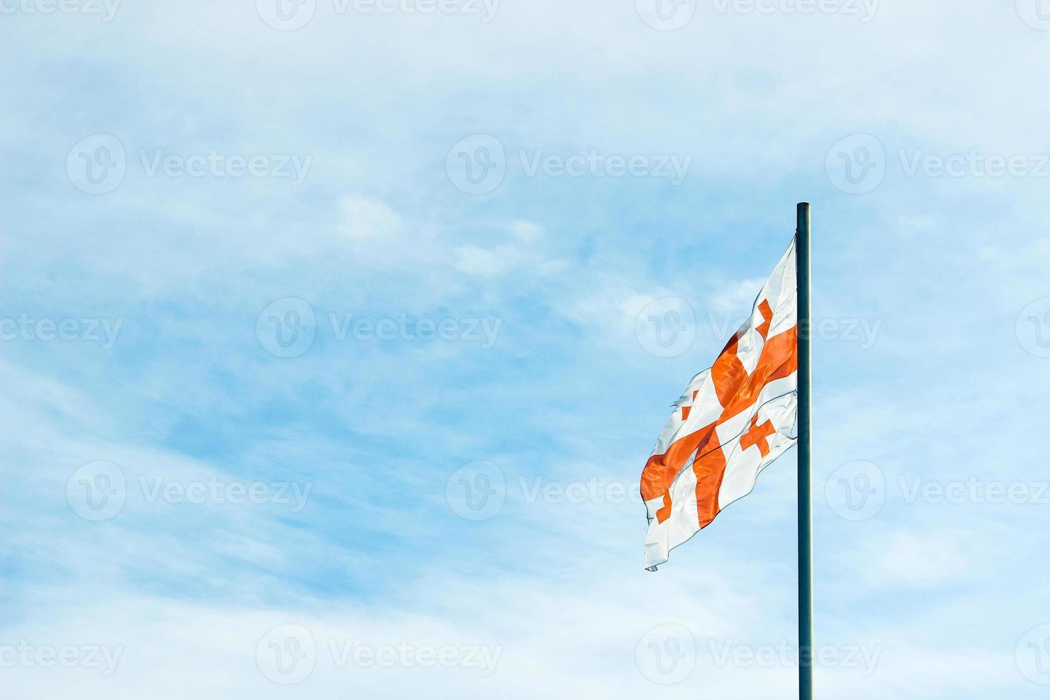View of The Georgian National Flag against  the blue sky. photo