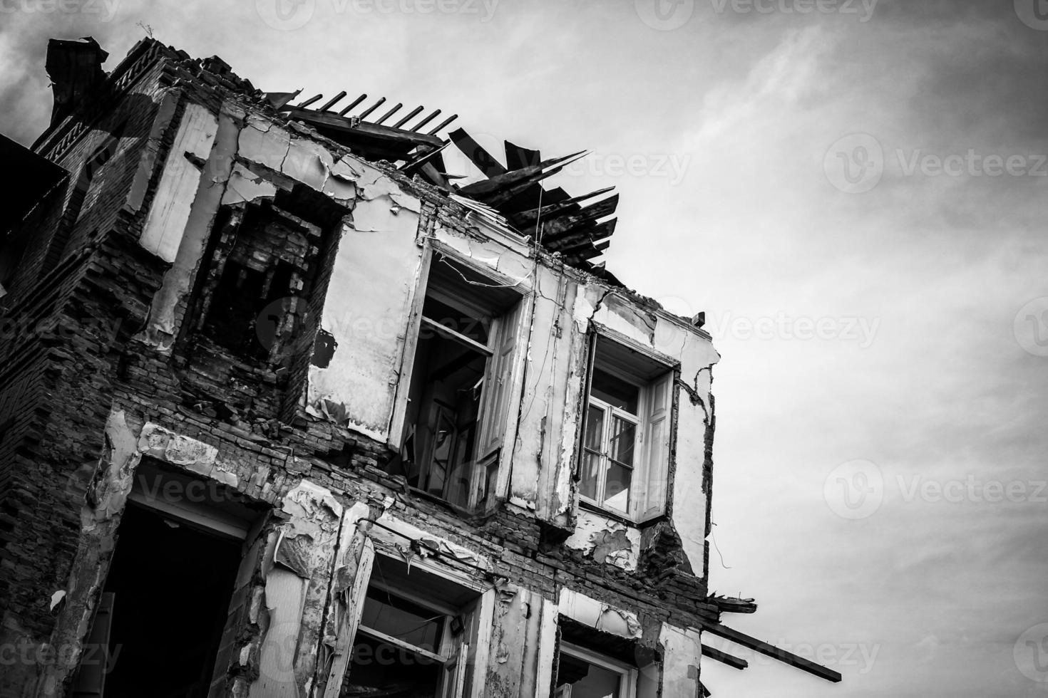 Black and white image of an abandoned and ruined old house. photo