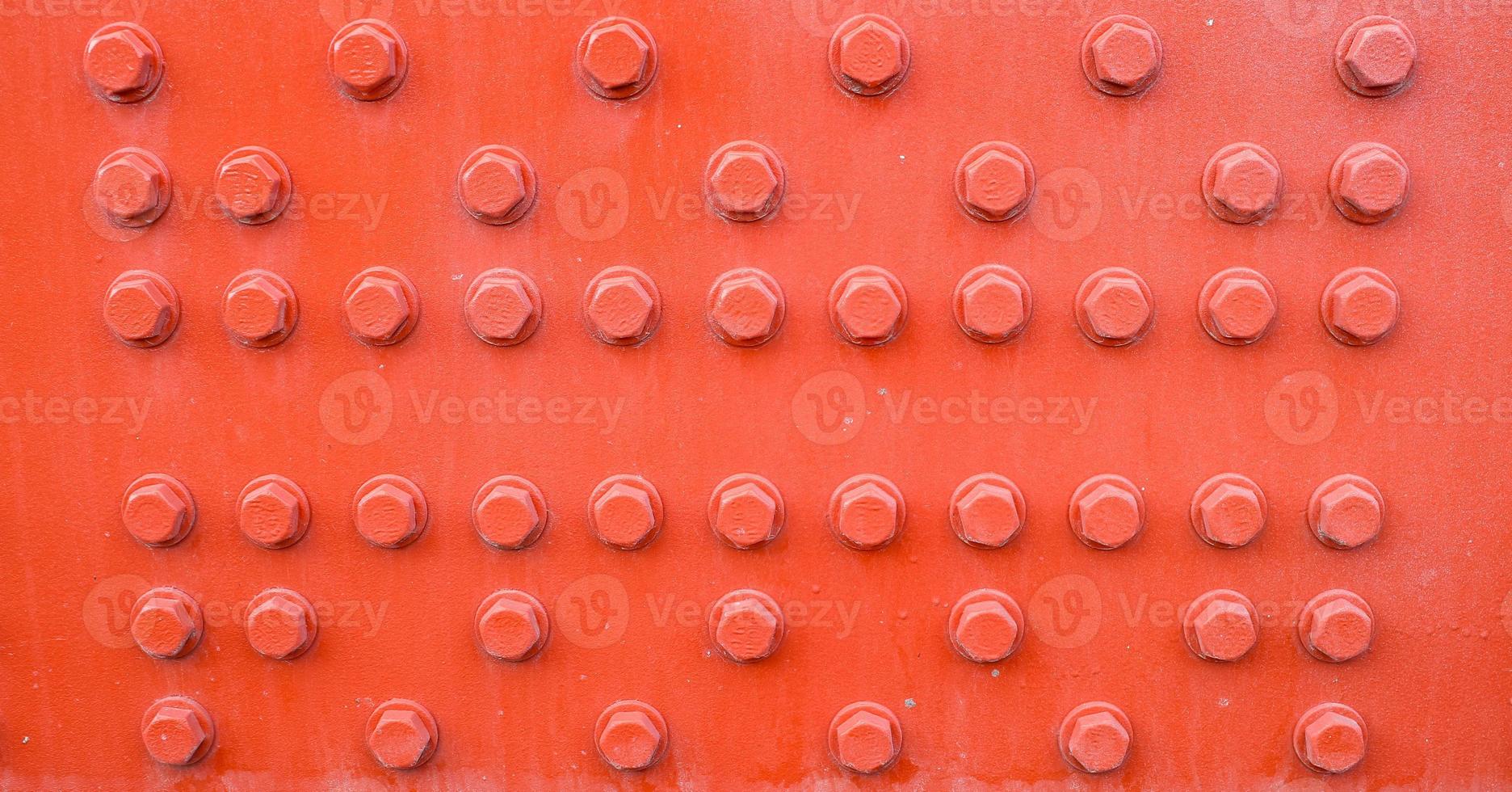 Red metal background with screws. photo
