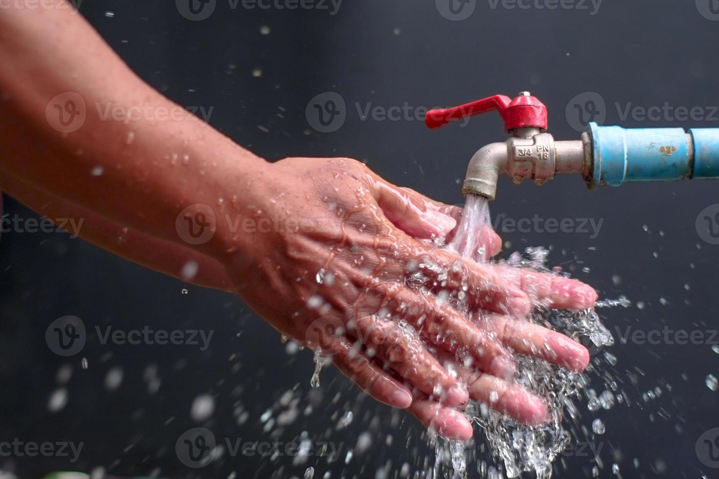 person washing hands in water photo