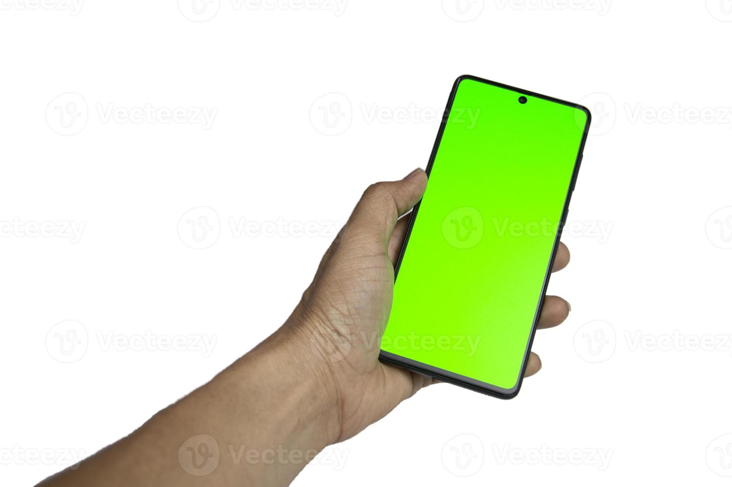 mano sujetando un smartphone negro de pantalla verde sobre fondo blanco, con trazado de recorte foto