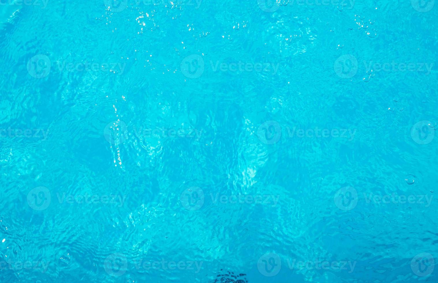 Blurred transparent blue colored clear calm water surface texture with splashes and bubbles. Trendy abstract nature background. Water waves in sunlight. water background photo