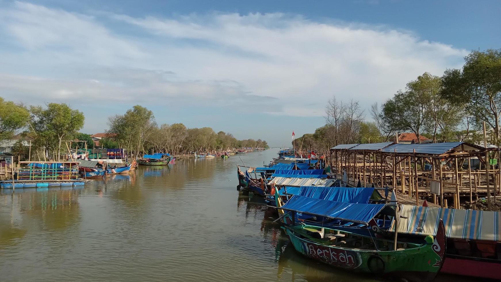 Fishing boats at the mouth of the river in Demak, Central Java, Indonesia photo