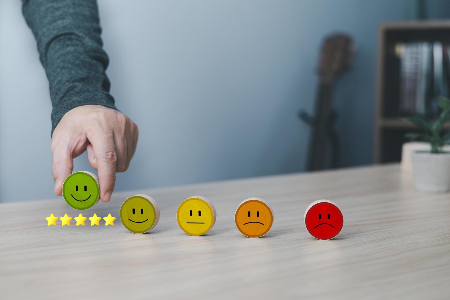 Hand of a businessman chooses a smile face on wood block circle.Customer service experience and business satisfaction survey.rating very impressed.Satisfaction survey concept.five Star Satisfaction photo