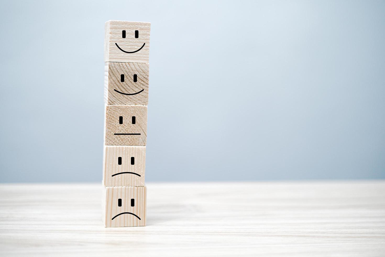 a smile face on wood block circle.Customer service experience and business satisfaction survey.rating very impressed.Satisfaction survey concept. photo