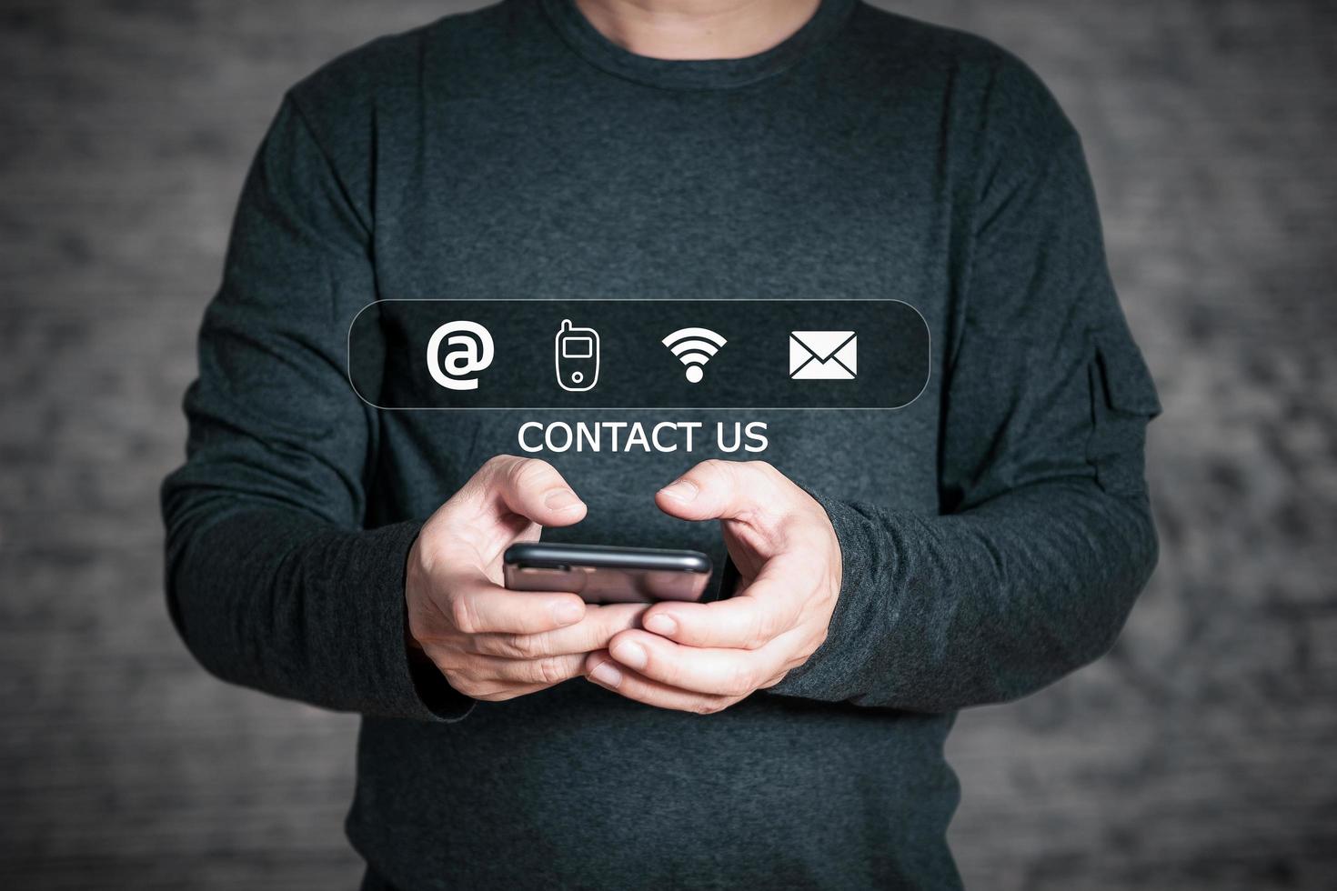 Businessman using smartphone and touch on virtual screen contact icons,address,phone,wifi,email,Contact us and Customer support hotline people connect. photo