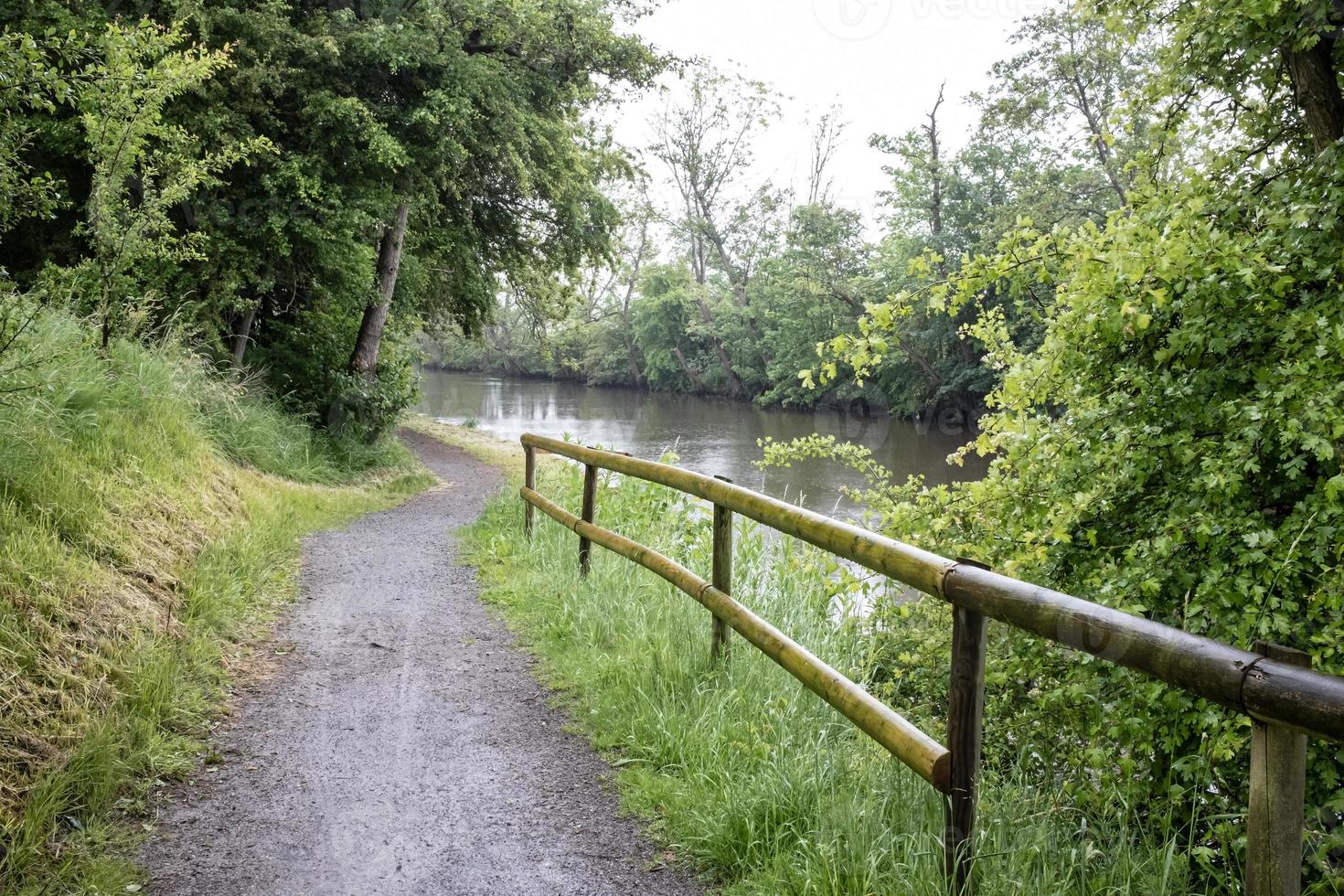 Camino para caminar y andar en bicicleta, con barandillas de madera para evitar caídas al río. paisaje. foto