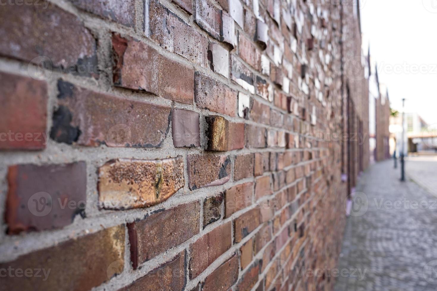 Brick wall of an ancient building on the street of a cozy provincial town. photo