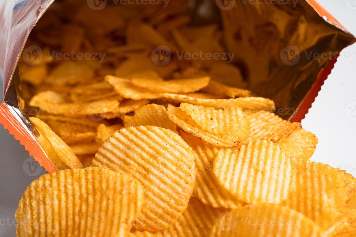 Potato chips, delicious BBQ seasoning spicy for crips, thin slice deep fried snack fast food in open bag. photo