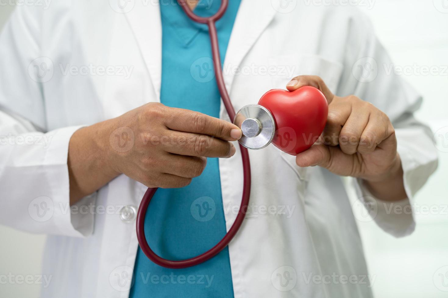 Doctor holding a red heart in hospital ward, healthy strong medical concept. photo