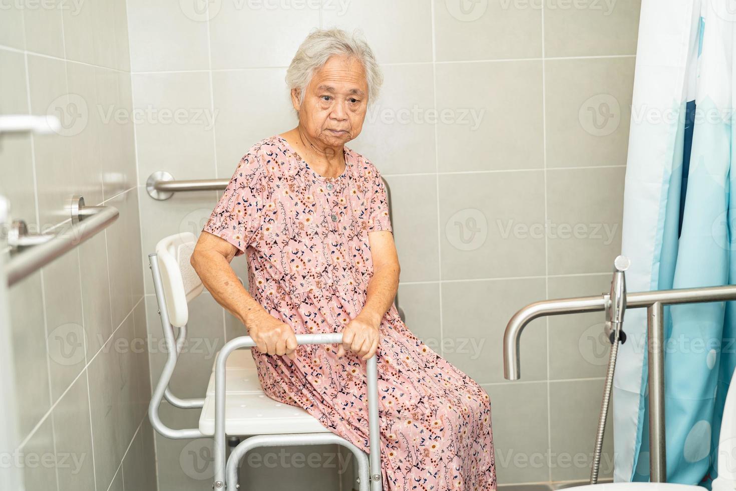 Asian elderly woman patient use toilet bathroom handle security in nursing hospital ward, healthy strong medical concept. photo