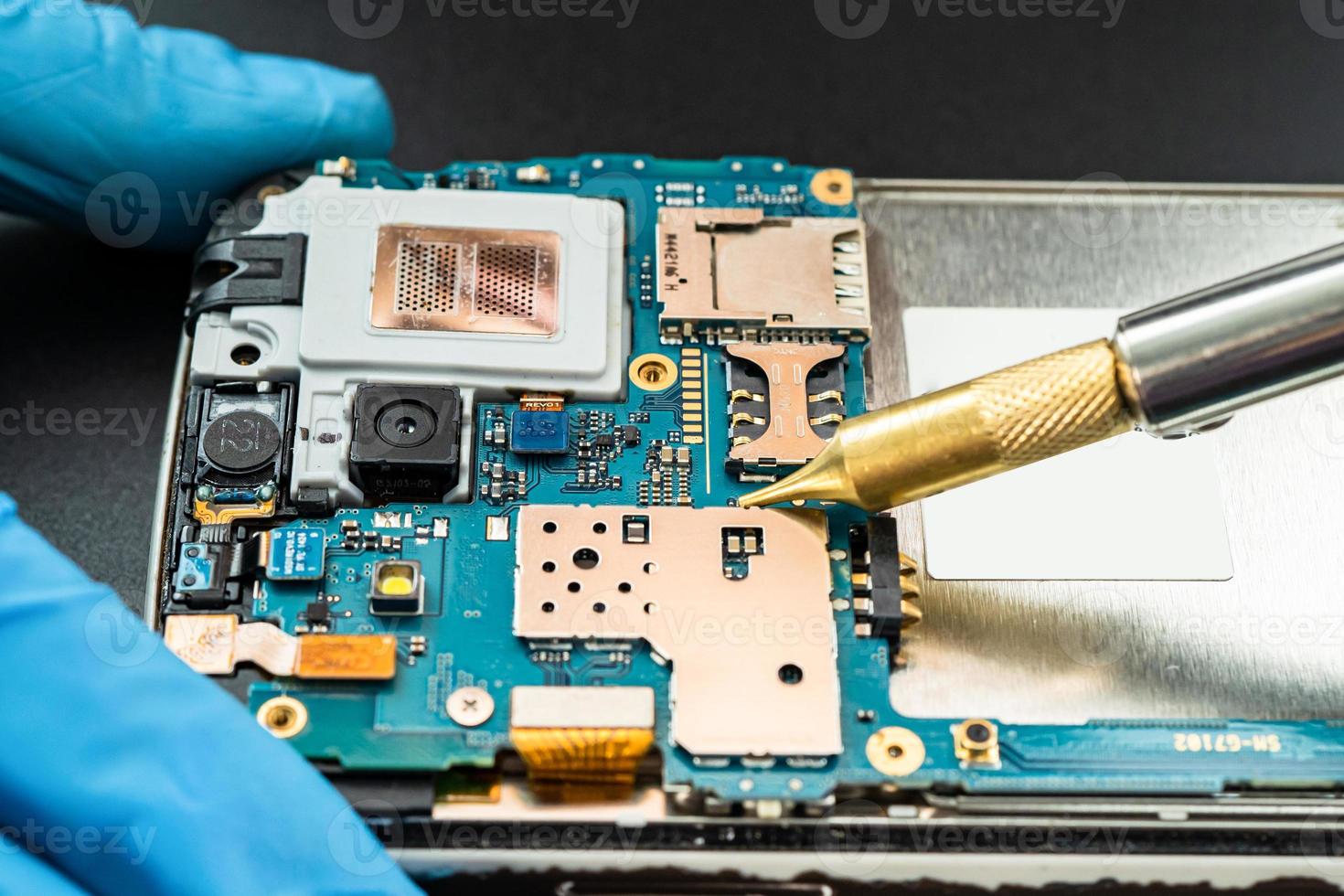 technician repairing inside of hard disk by soldering iron. Integrated Circuit. the concept of data, hardware, technician and technology. photo