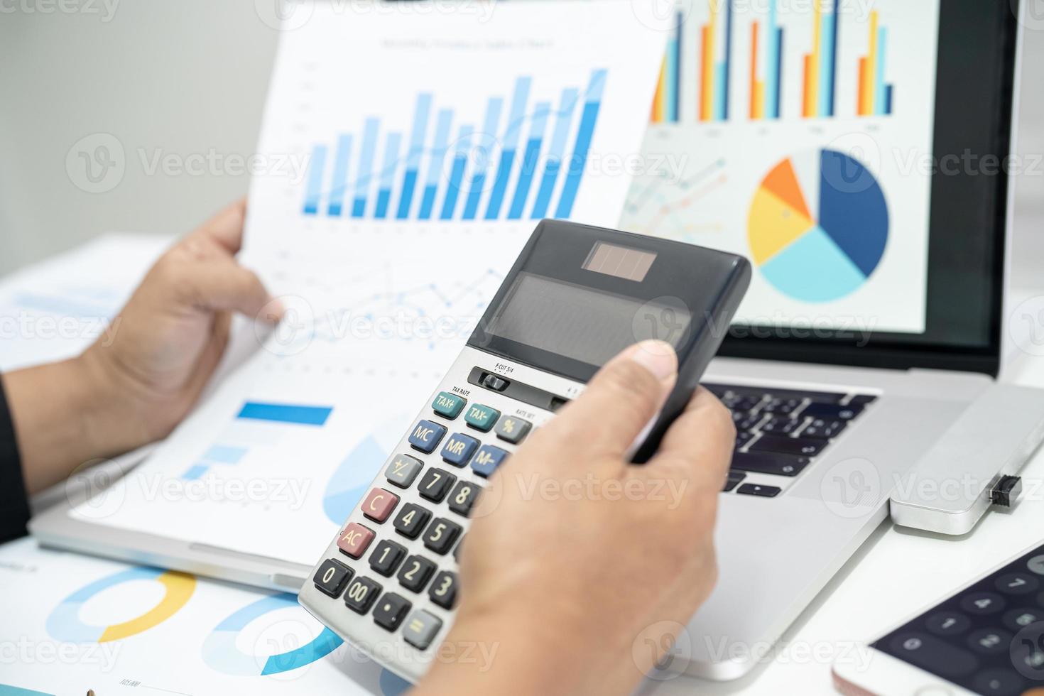 Asian accountant working and analyzing financial reports project accounting with chart graph in modern office, finance and business concept. photo