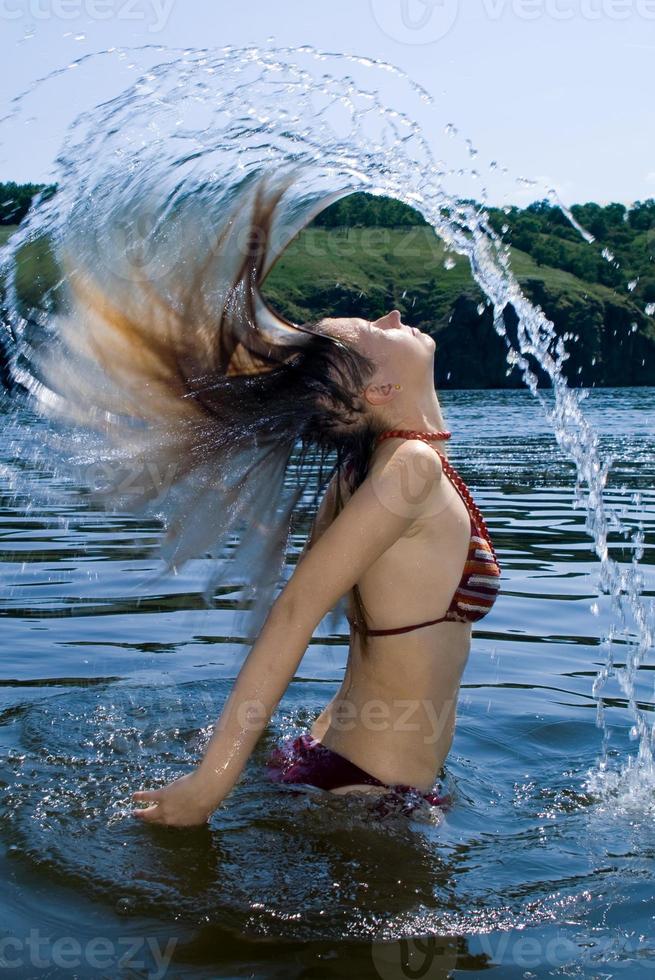 The young woman bathes in the river photo