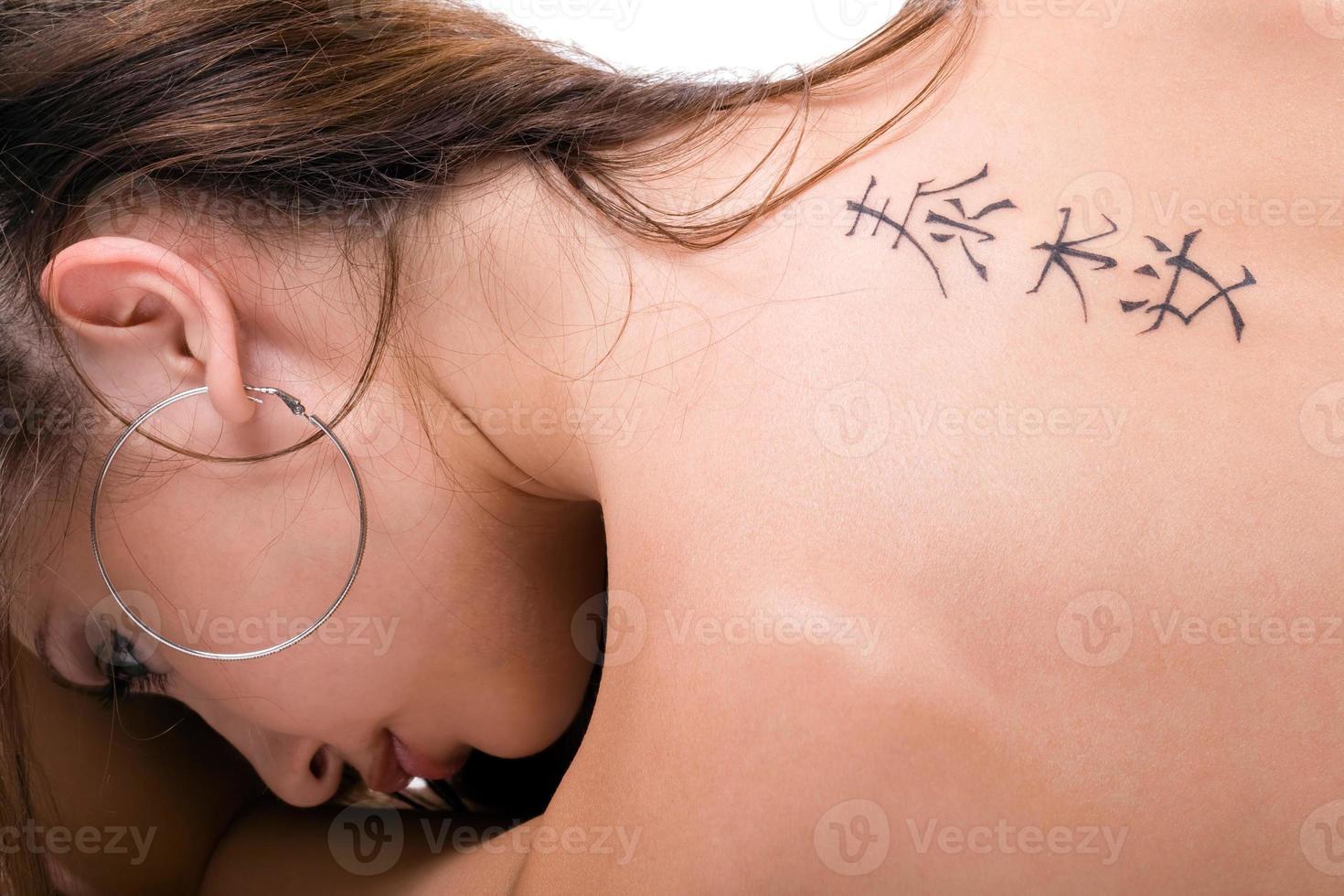 Tattoo on a back of the young woman. Isolated 2 photo