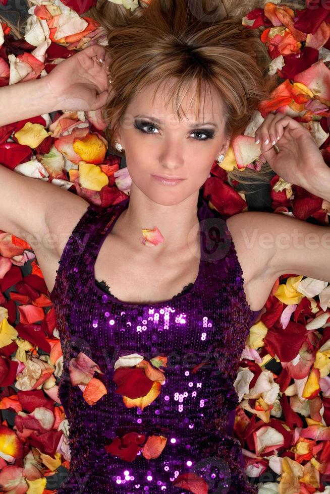 sensual young blonde lying in rose petals photo