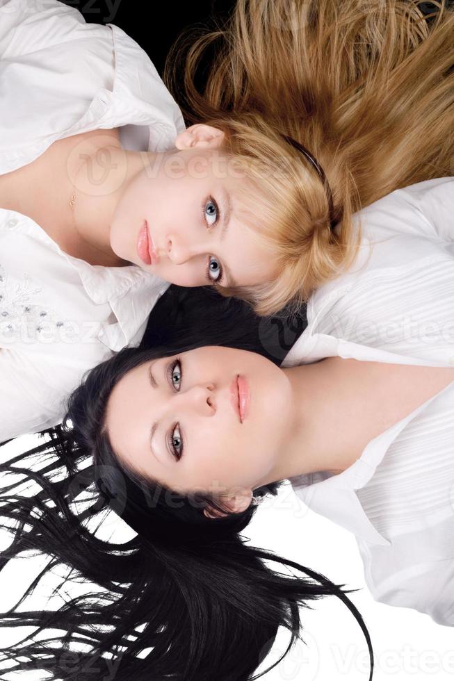 Portrait of two lying beautiful young women photo