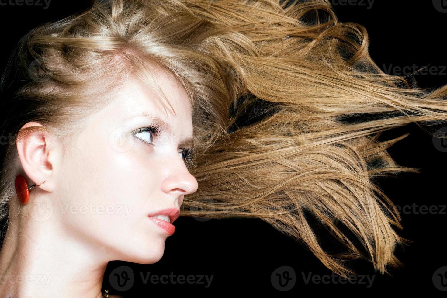 Portrait of the young beauty blonde. Isolated on black background photo