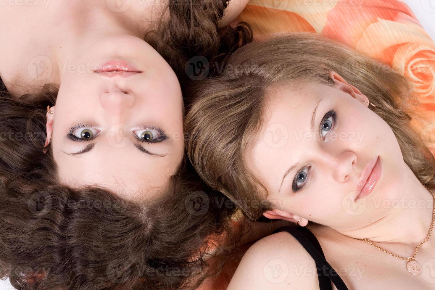 Portrait of the two beauty young women laying on a pillow 1 photo