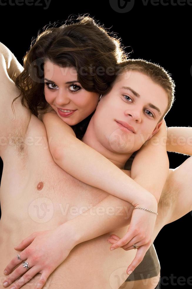 Beautiful playful young couple. Isolated on black background photo