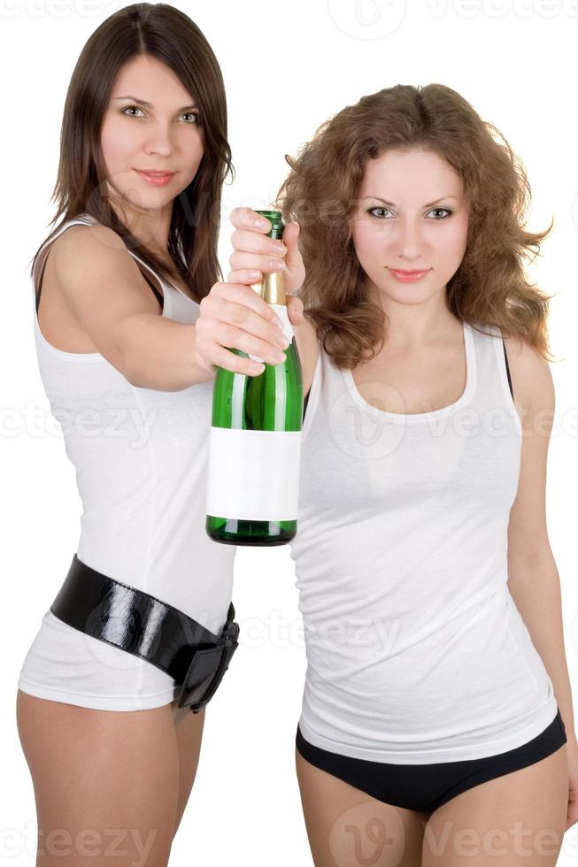 Two beautiful girls with a champagne bottle. Isolated photo