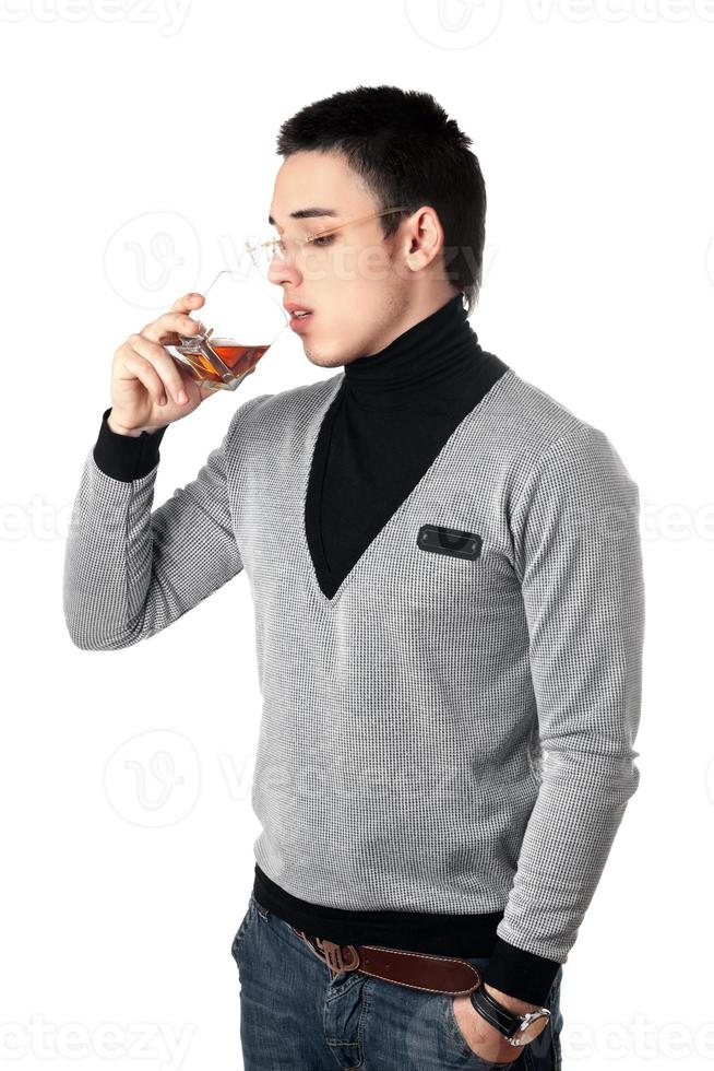 Young man drinking whiskey from a glass photo