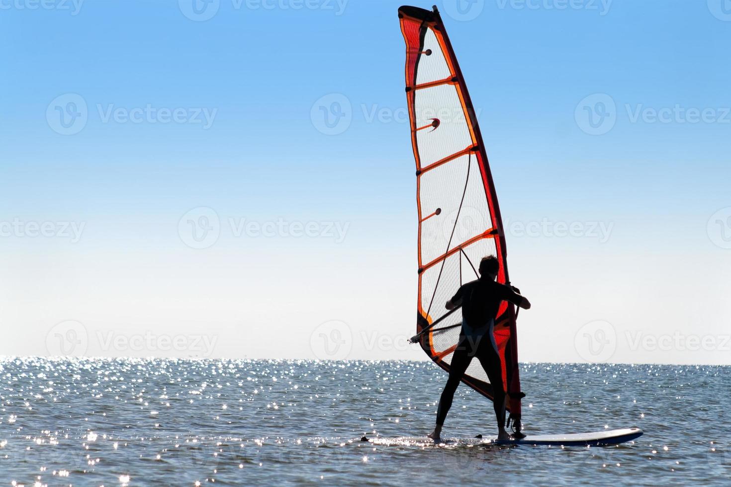 Silhouette of a windsurfer photo